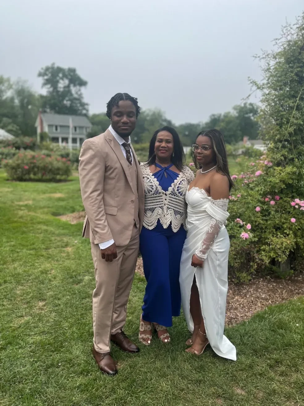 Couple with officiant in a rose garden ceremony