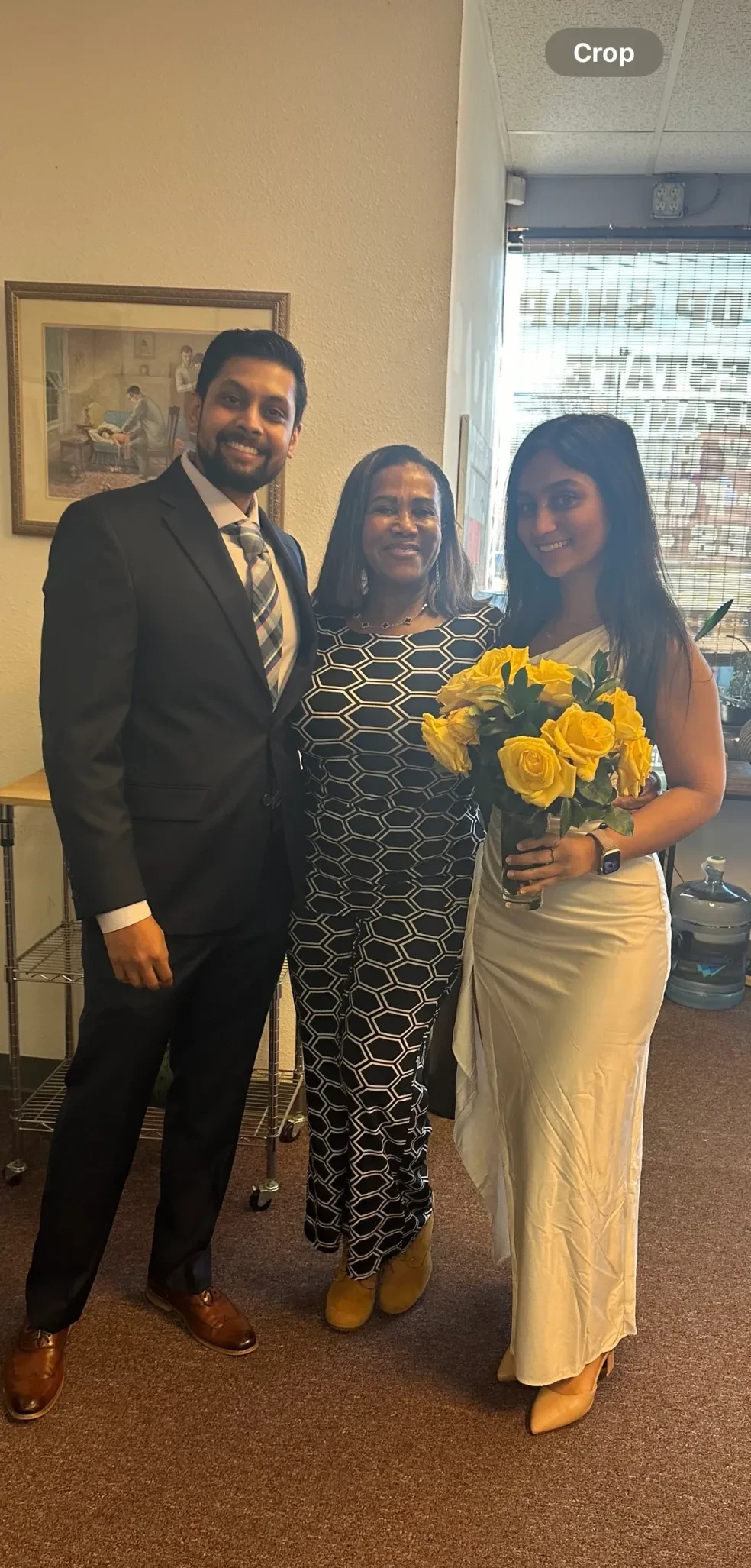 Couple with officiant holding yellow roses at a chapel ceremony